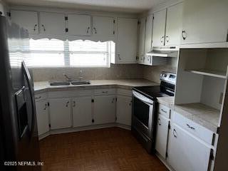 kitchen featuring tasteful backsplash, appliances with stainless steel finishes, light countertops, under cabinet range hood, and a sink