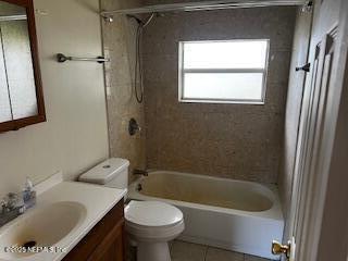 full bath featuring tile patterned flooring, bathing tub / shower combination, toilet, and vanity