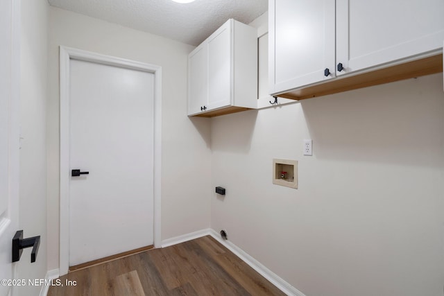 washroom featuring cabinets, washer hookup, dark wood-type flooring, hookup for an electric dryer, and a textured ceiling