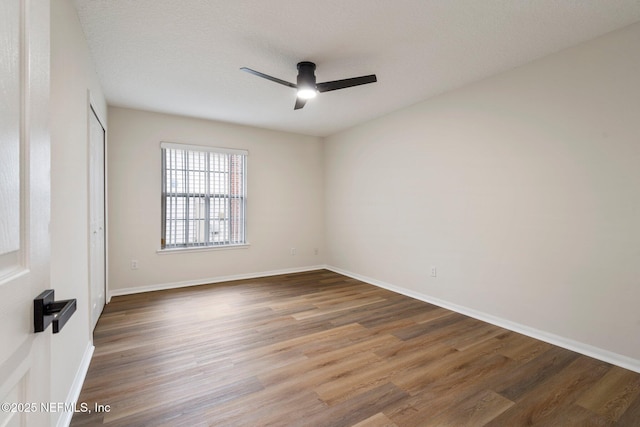 empty room with hardwood / wood-style flooring, a textured ceiling, and ceiling fan