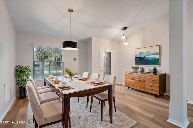 dining area featuring light hardwood / wood-style flooring and vaulted ceiling