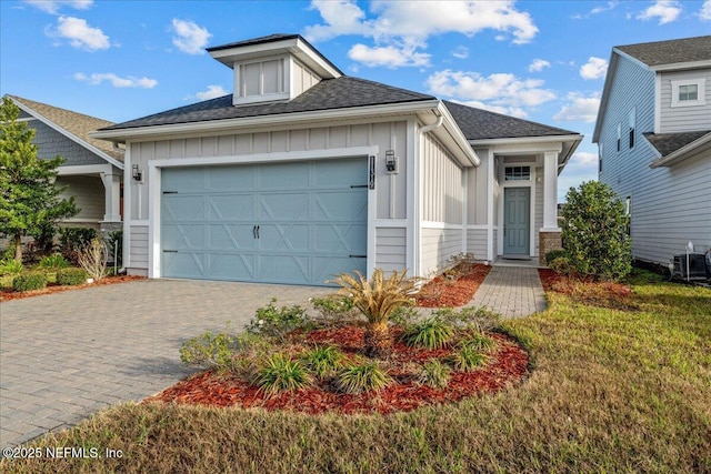 view of front of home featuring a garage, a front lawn, and central air condition unit