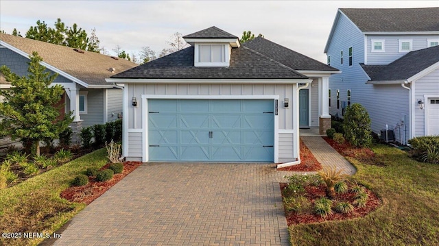 view of front facade with a garage and central air condition unit