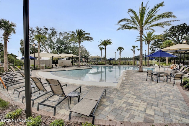 community pool with a patio and fence