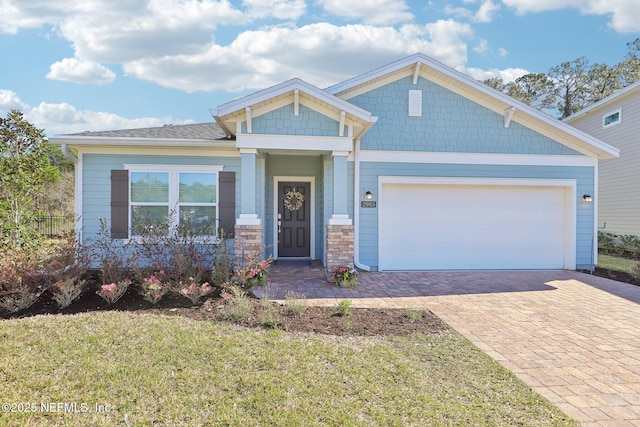 craftsman-style house with an attached garage and decorative driveway