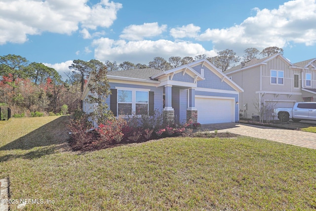 view of front facade with decorative driveway, an attached garage, and a front lawn