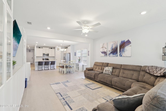 living room with recessed lighting, visible vents, a ceiling fan, and light wood finished floors