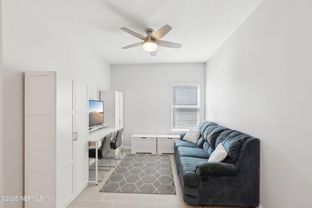 living area with a textured ceiling, light tile patterned flooring, baseboards, ceiling fan, and built in study area