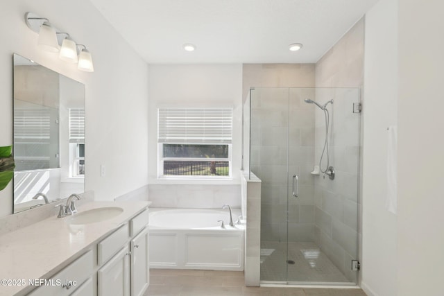 full bathroom featuring a shower stall, vanity, and a garden tub