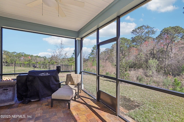 sunroom / solarium with a healthy amount of sunlight and ceiling fan