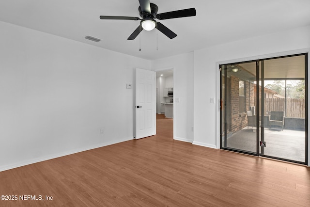 spare room with visible vents, ceiling fan, light wood-style flooring, and baseboards