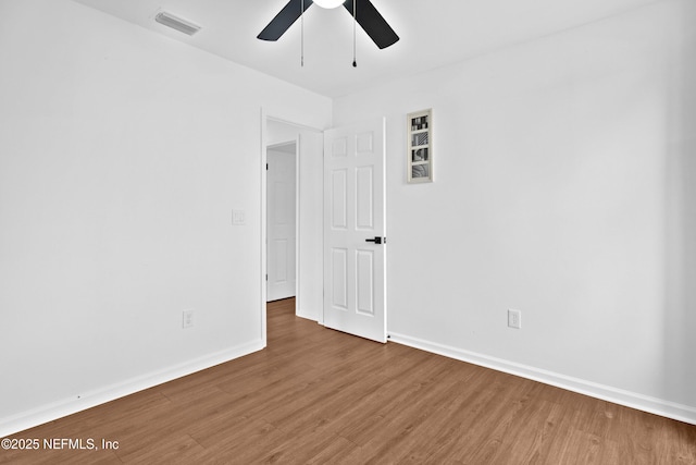 unfurnished room with visible vents, ceiling fan, baseboards, and wood finished floors