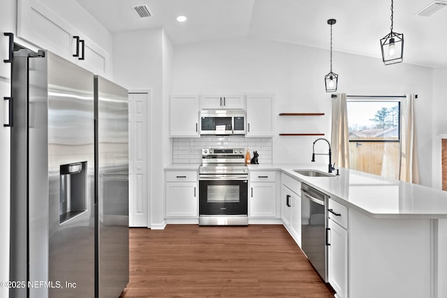 kitchen featuring stainless steel appliances, white cabinetry, hanging light fixtures, and open shelves