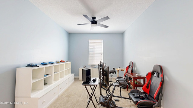 game room with a textured ceiling, a ceiling fan, and light colored carpet