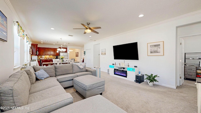 living area with baseboards, light colored carpet, ornamental molding, ceiling fan with notable chandelier, and recessed lighting