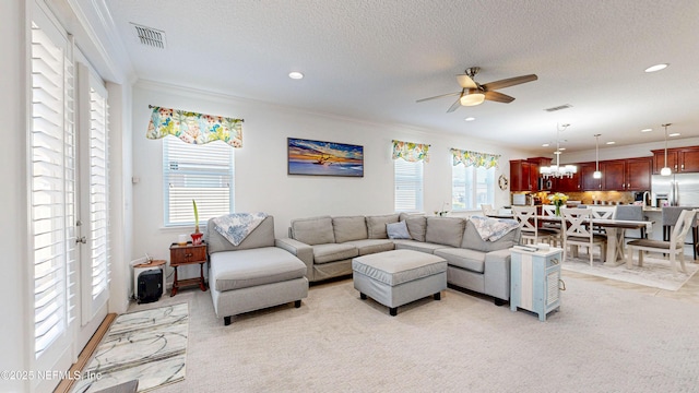 living area featuring a healthy amount of sunlight, visible vents, and a ceiling fan