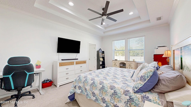 bedroom with light carpet, visible vents, a raised ceiling, ceiling fan, and crown molding