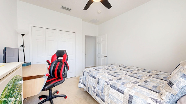 bedroom featuring light carpet, ceiling fan, visible vents, and a closet