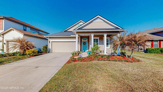 neoclassical home with an attached garage, concrete driveway, a porch, and a front yard