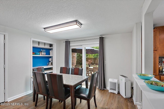 dining area with hardwood / wood-style flooring and a textured ceiling