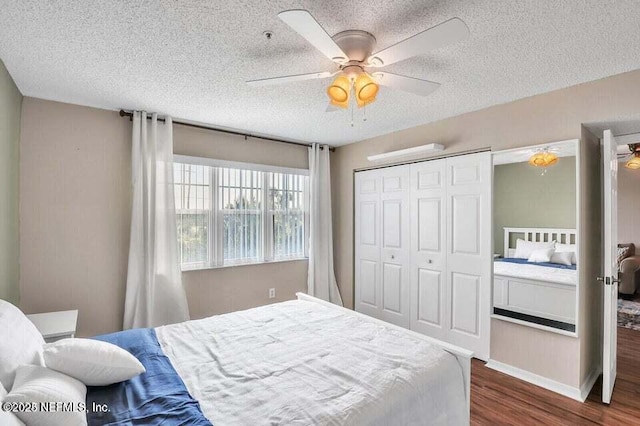 bedroom with a closet, dark hardwood / wood-style floors, a textured ceiling, and ceiling fan