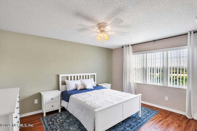 bedroom featuring ceiling fan, dark wood-type flooring, and a textured ceiling