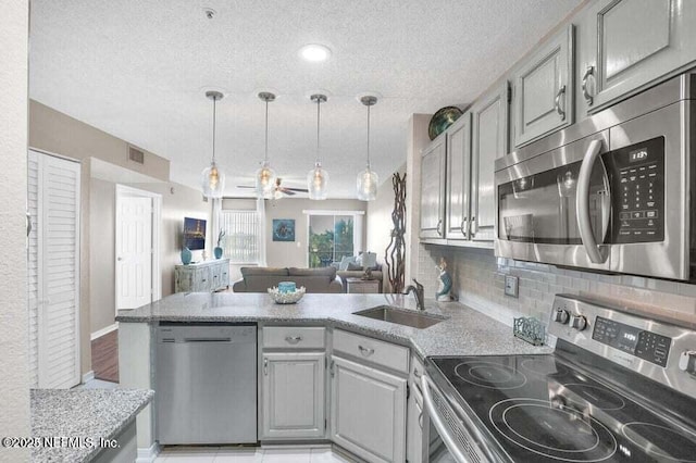 kitchen with stainless steel appliances, sink, pendant lighting, and gray cabinets