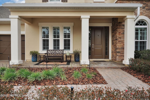 view of exterior entry featuring covered porch