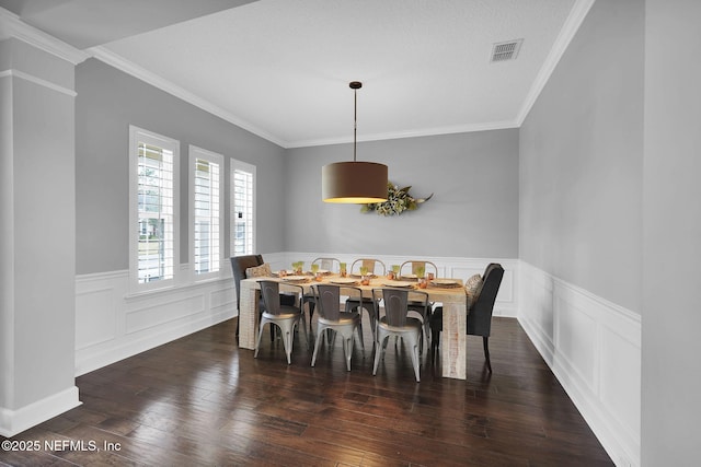 dining room featuring ornamental molding, dark wood-type flooring, and a textured ceiling