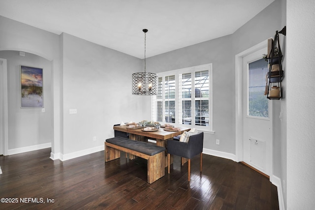 dining area featuring an inviting chandelier and dark wood-type flooring