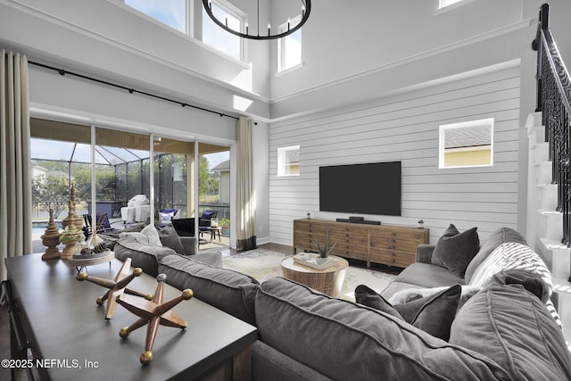 living room featuring a high ceiling and wooden walls