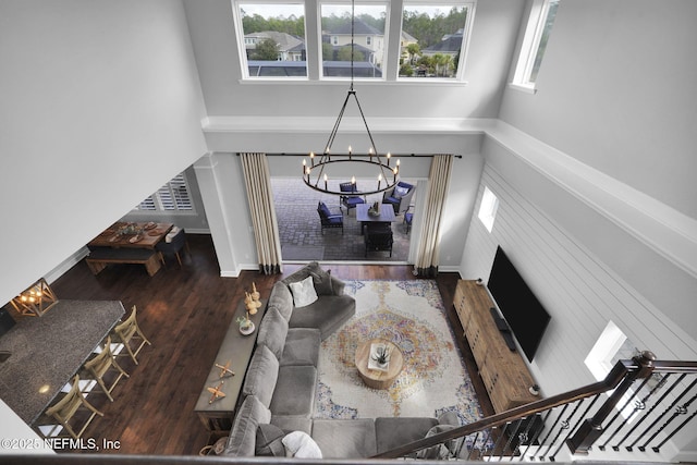 living room featuring a chandelier, dark hardwood / wood-style flooring, plenty of natural light, and a high ceiling