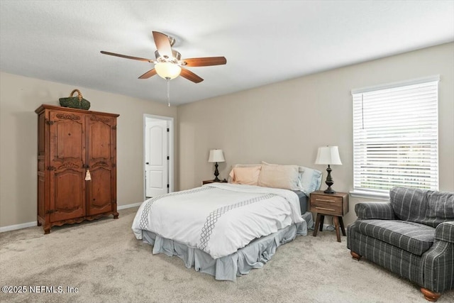 bedroom featuring a ceiling fan, light carpet, and baseboards