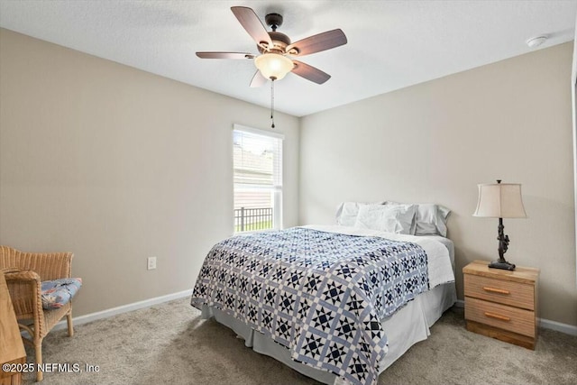 carpeted bedroom with ceiling fan and baseboards