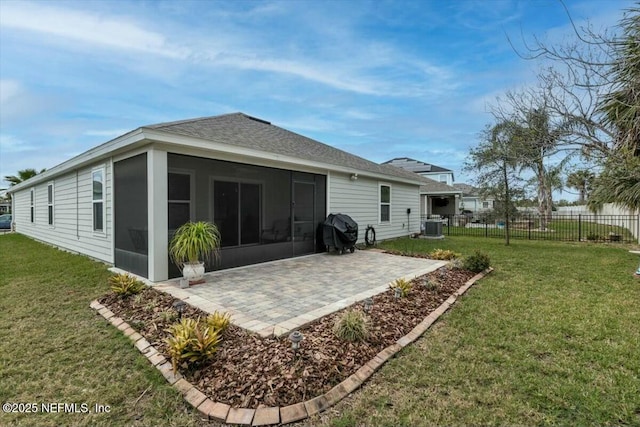 back of property with a yard, a sunroom, a patio area, central AC, and fence