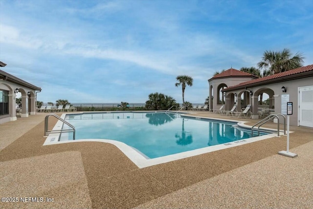 community pool featuring a patio and fence