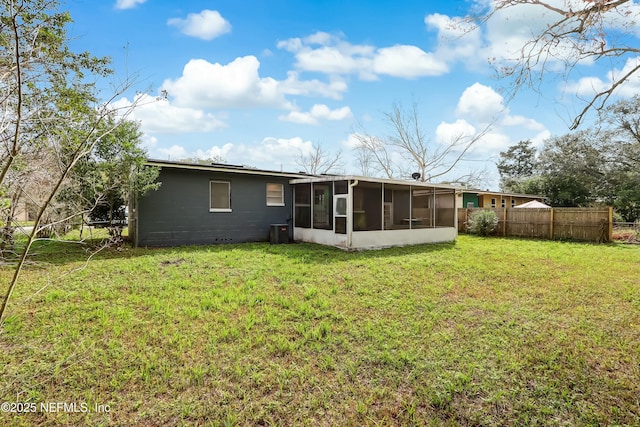 back of property featuring cooling unit, a sunroom, and a lawn