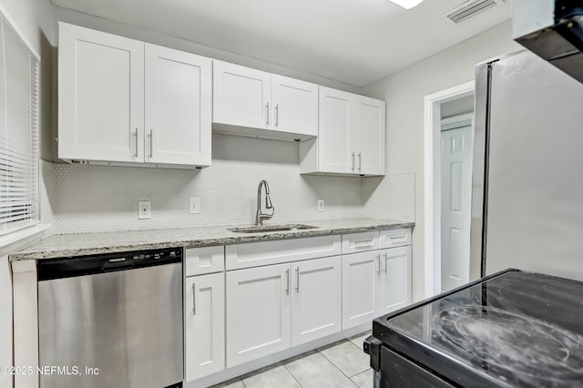 kitchen with sink, stainless steel appliances, light stone countertops, white cabinets, and decorative backsplash