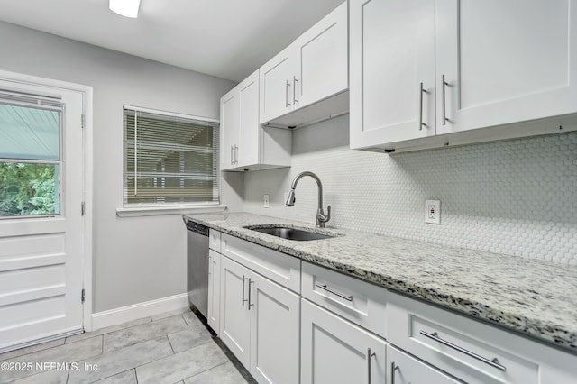 kitchen with sink, light stone countertops, and white cabinets