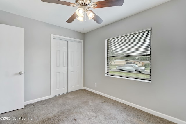 unfurnished bedroom with light carpet, ceiling fan, and a closet