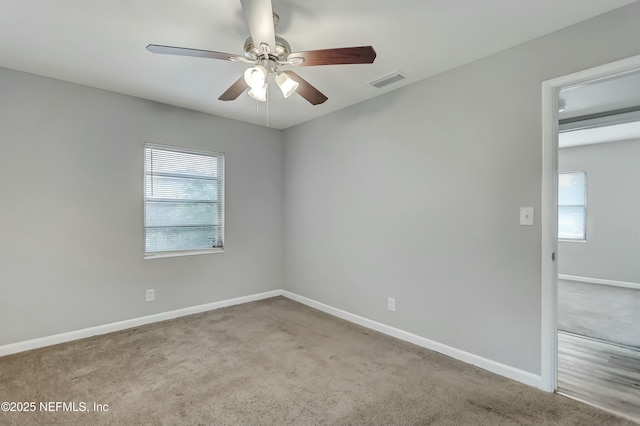 unfurnished room with light colored carpet and ceiling fan