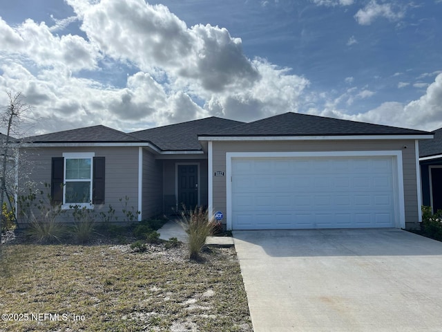 ranch-style home featuring concrete driveway, roof with shingles, and an attached garage