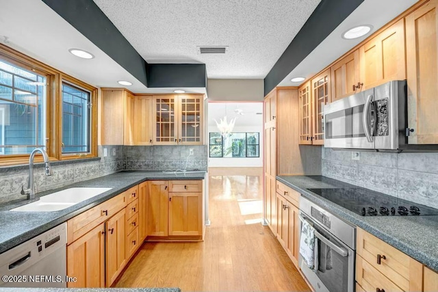 kitchen with sink, light brown cabinetry, appliances with stainless steel finishes, and light wood-type flooring