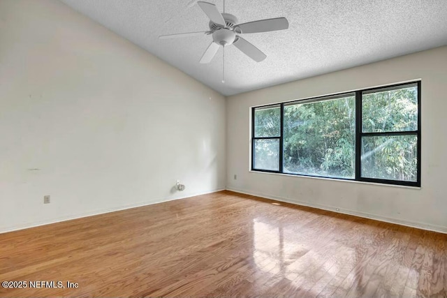 empty room with light hardwood / wood-style floors, vaulted ceiling, and a healthy amount of sunlight