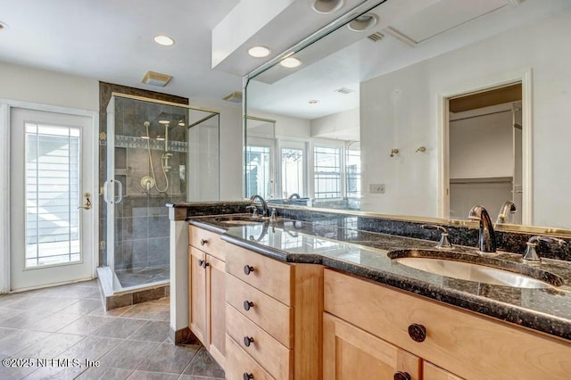 bathroom featuring tile patterned flooring, vanity, and a shower with door