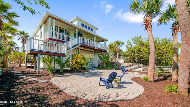 view of front of house with stairs, a patio, and fence