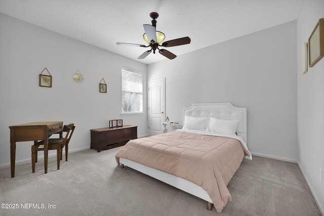 bedroom featuring light carpet, a textured ceiling, a ceiling fan, and baseboards