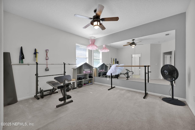 exercise room featuring carpet floors, visible vents, baseboards, and a textured ceiling