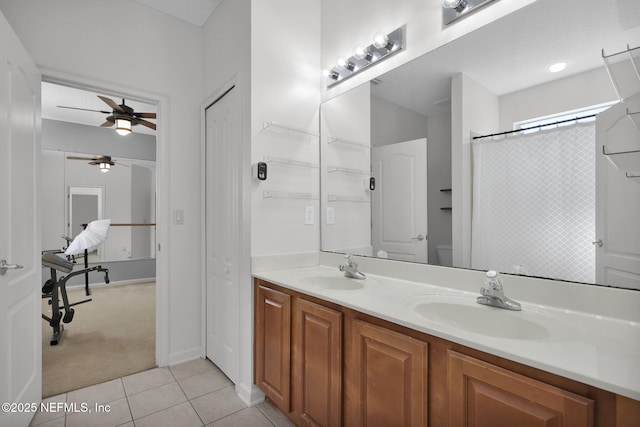 bathroom with ceiling fan, double vanity, tile patterned flooring, and a sink