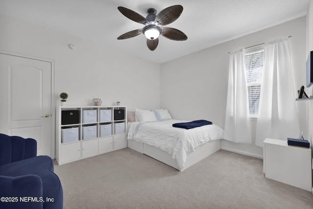 bedroom featuring carpet floors, ceiling fan, and a textured ceiling